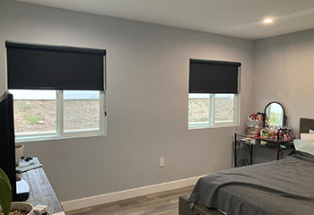 Modern living room with fireplace and black roller shades